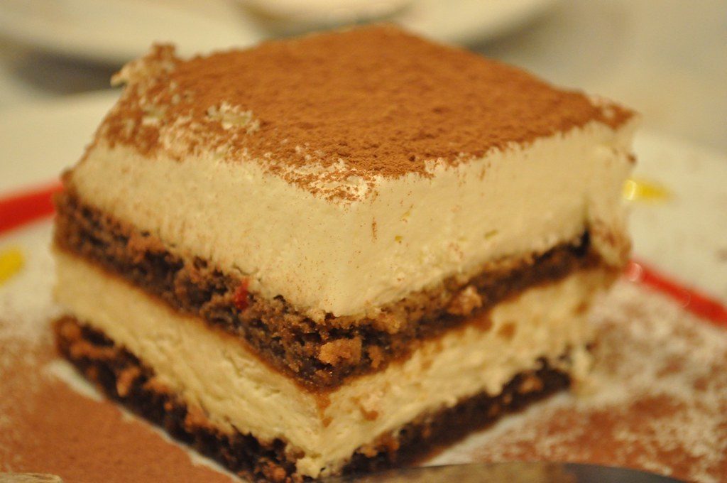 A close-up of a slice of tiramisu dusted with cocoa
